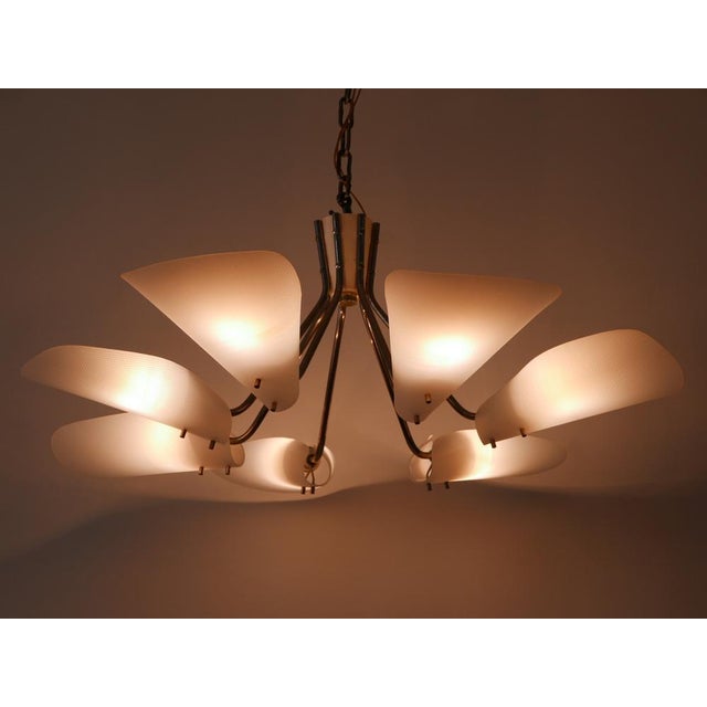 Gorgeous, highly decorative Mid-Century Modern seven-armed chandelier or pendant lamp. Designed and manufactured in...