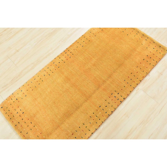 A contemporary Gabbeh rug hand-knotted with an all-wool pile on a cotton foundation. This finely woven rug features a...