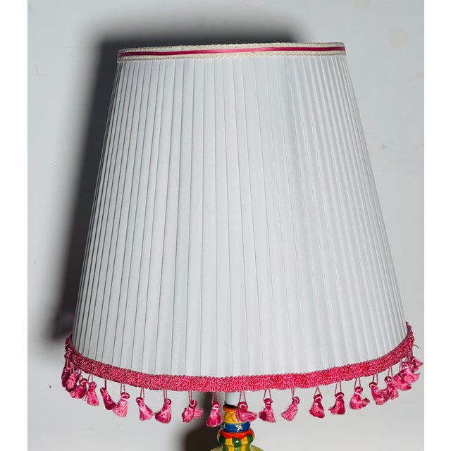 Beautiful white pleated lamp shade decorated with pink fringes and silk ribbon. Bottom 16”, Top 10” Height 14”.