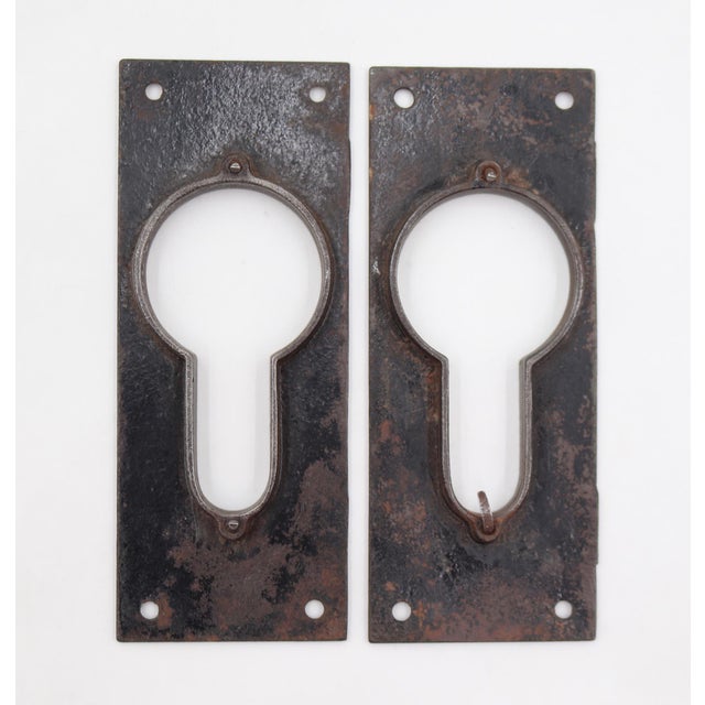 Antique Aesthetic style pocket door front plates made of cast iron with a raw gray-black iron finish. The recessed backs...