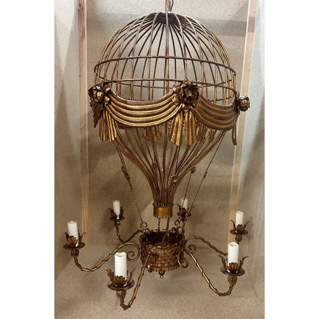 Unusual and whimsical gilt and bronzed tole hot air balloon form chandelier. Balloon adorned with draped swags and roses....