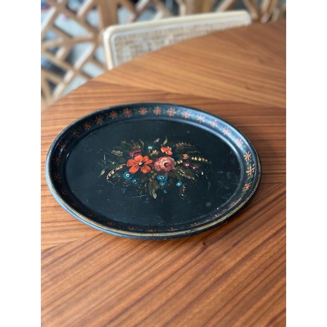 This beautiful antique toleware tray features a hand-painted floral centerpiece on a black background framed in a dainty...