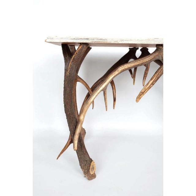 Interesting table made of solid oak in combination with a deer antler base. The top is patinated with old-white brushed...