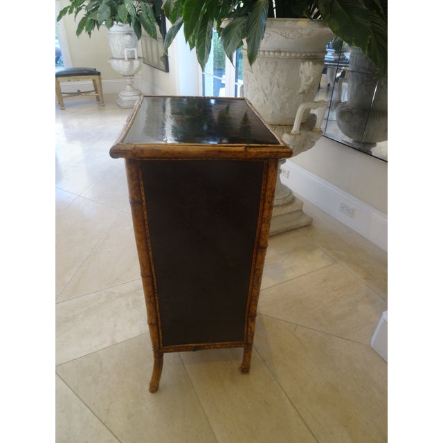 An exquisite bookcase with a fabulous lacquered top showcasing a bird and flowers.