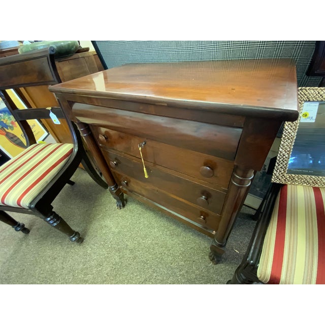 Early 19th century Empire style small chest of drawers. Three drawers with pulls, rolled top drawer. Column and paw feet...
