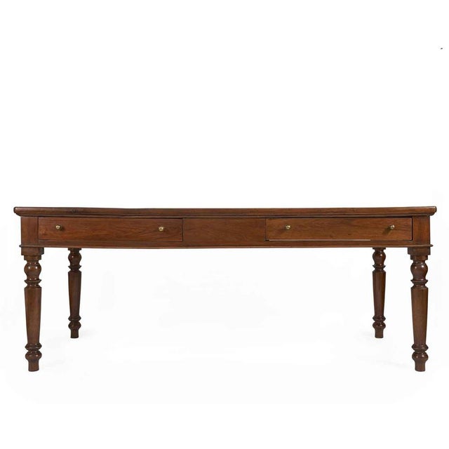 A perfectly restored 19th-century rectangular walnut dining table with drawers, finished with shellac and wax. The...