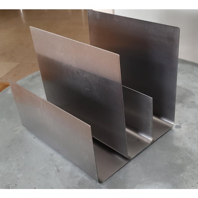 This brushed aluminum magazine rack, emblematic of the "space age" style of the 1970s in France, embodies the audacity and...