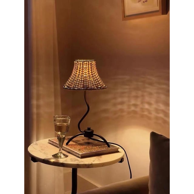 Shade is light beige rattan (natural woven texture, soft light transmission), body is matte black iron curved arm + three-...