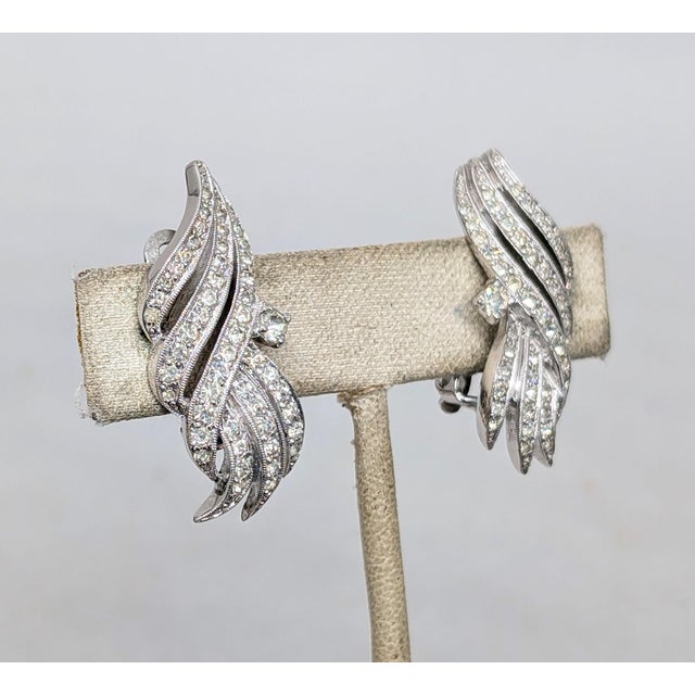 1960s rhodium plated pavé round clear rhinestones clip earrings. Marked "Polcini©" on the clips and on the back of one...