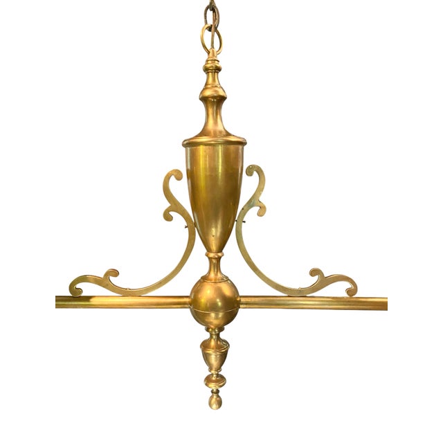 Three light sockets under a black tole/brass shade on each end, raised on turned brass legs with ball feet, joined by a...