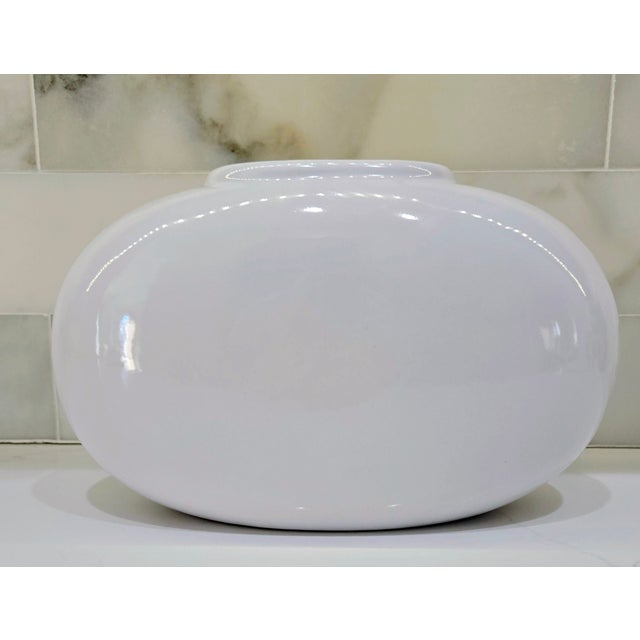 Bring a touch of mid-century modern charm to your space with this sculptural white Haeger low oval vase. Its flattened,...