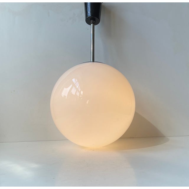 A white cased opaline glass and nickel plated steel pendant Light manufactured by Lyfa or Louis Poulsen (18063-65) in...