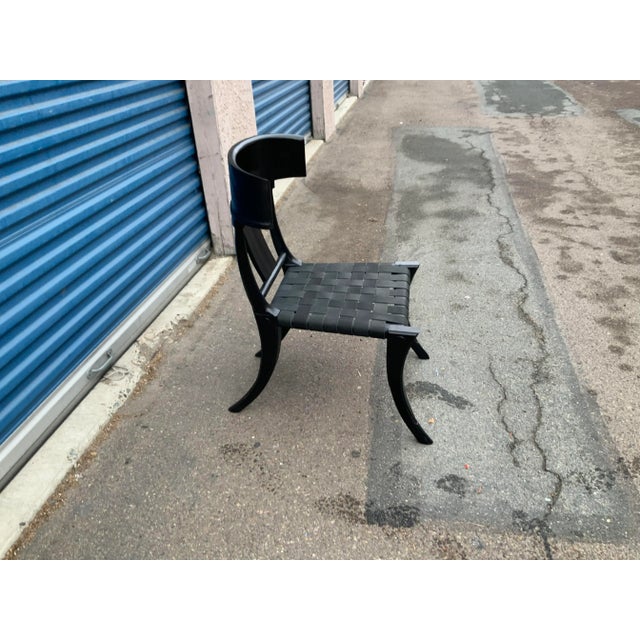 Mid century style dining chair. The Klismos style dining chair is made of alder with a matte black finish. The straps are...