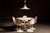 Five-piece tulip-style dining set accompanied by a matching hardwired, sculptural pendant light, all rendered in a...
