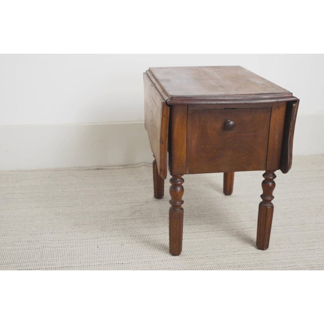 Antique French Pembroke drop leaf table featuring beautifully figured walnut veneer, two drawers, a pull-out shelf door,...