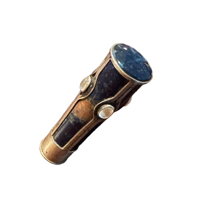 The blue and rust colored hardstone mounted en cage in silver inset with 4 oval moonstones and ‘RE’ seal. Hallmarked with...