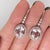 Turn heads with these warm peachy-pink Morganite drop earrings, set in solid 14K White Gold. Each earring centers a hand-...