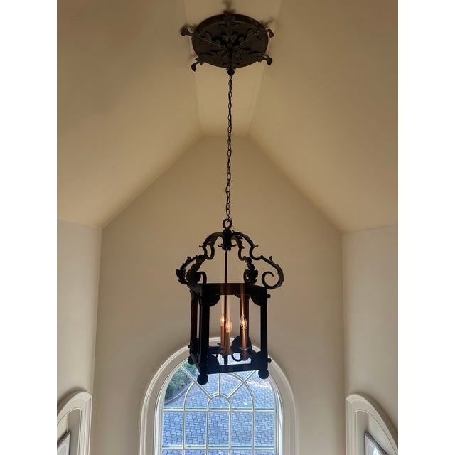Wrought Iron leaf motif lantern with decorative top and large embellished canopy.