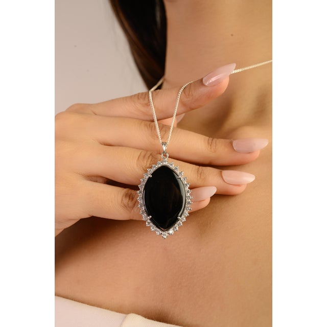 This stunning 925 sterling silver pendant features a pear-shaped black onyx gemstone measuring 30 x 20 mm and weighing 26...