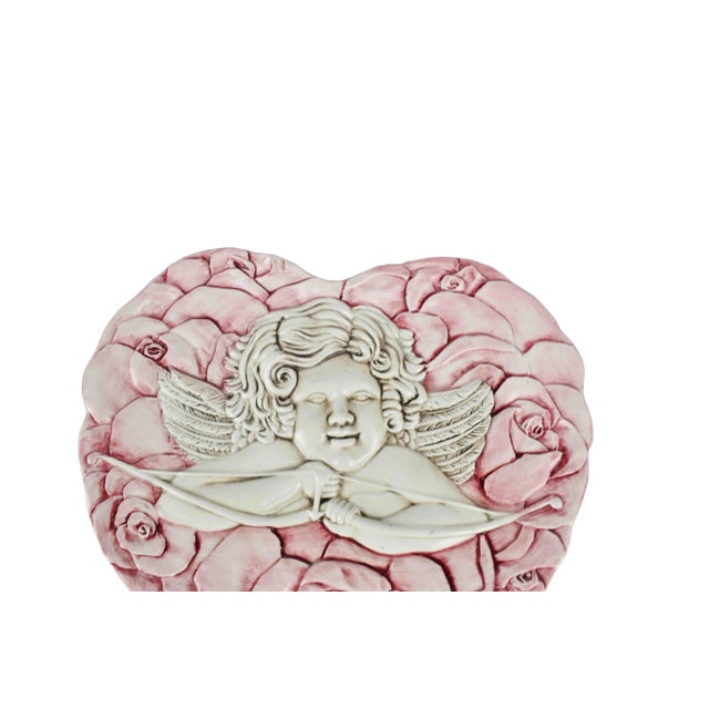 Stunning hand crafted Italian heart shape putto (cherub) with pink roses all around decorative wall hanging plate. It is...