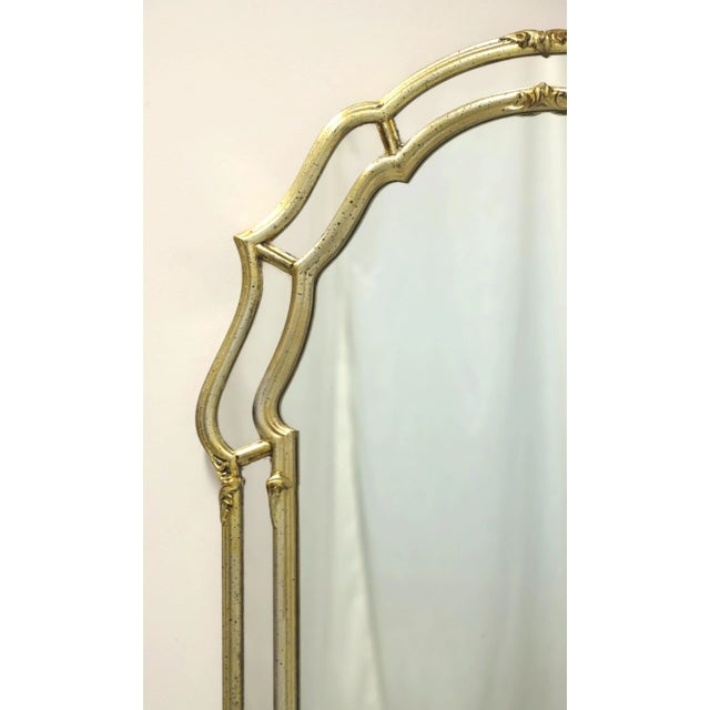 A Regency style parclose wall mirror by Labarge. Mirrored glass in a solid wood frame painted gold. Features arched top...
