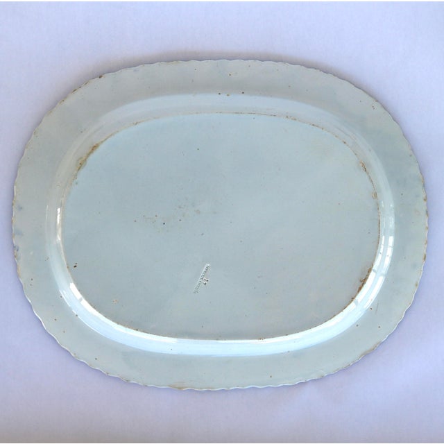 An authentic, early 19th-century English pearlware oval serving platter featuring a classic hand-brushed blue feather-edge...