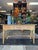 This stunning vintage rattan console table is a rare coastal-modern gem. Featuring three woven cane-front drawers and a...