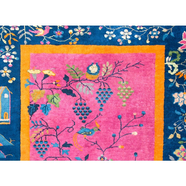 A wonderful early 20th century Chinese Art Deco rug with a brilliant fuchsia field surrounded by thin orange, wide indigo,...