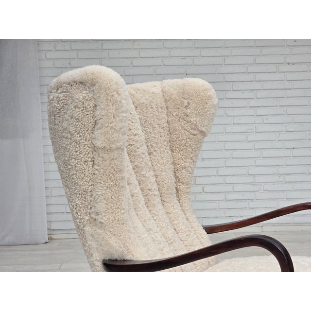 1960s Danish high-backed armchair. Reupholstered in high-quality genuine sheepskin from New Zealand/Australia, with OEKO-...