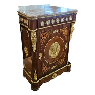 The Gilded Emblem – French-Inspired Marble-Top Commode With Ornate Floral Medallion & Luxurious Gold Accents For Sale