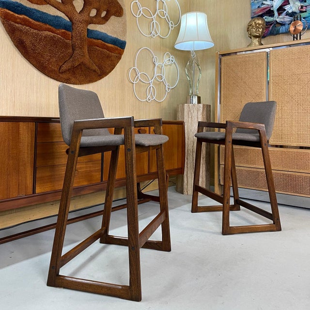 Pair of restored Danish teak counter height barstools in new taupe upholstery. These stools date from 1980s. They were...