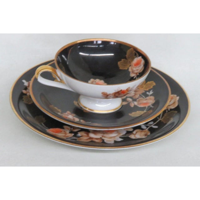 This lovely set of a tea cup, saucer, and dessert plate is made of porcelain. This set is stamped as being made by Rudolf...