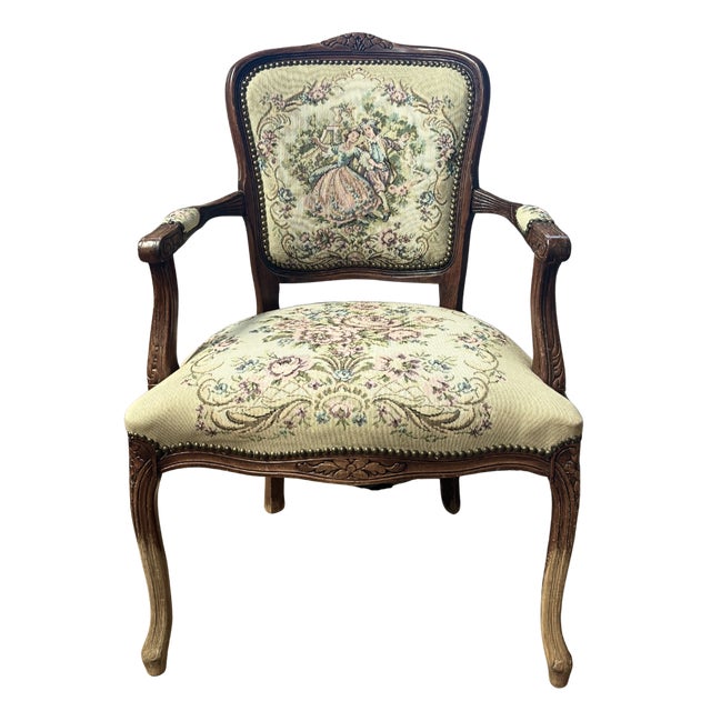 A charming vintage French-style armchair featuring a carved wood frame, gently curved cabriole legs, and upholstered...