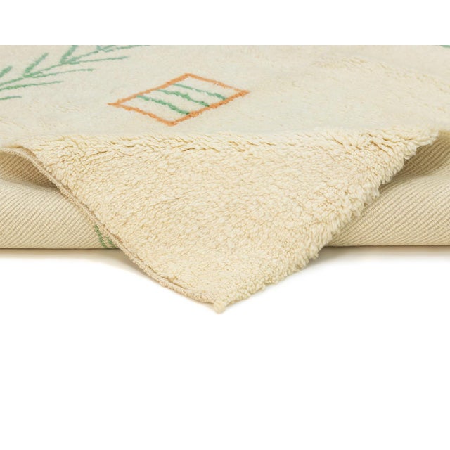 Scattered symbolic motifs float across an open ivory field, echoing the storytelling language of traditional Berber...