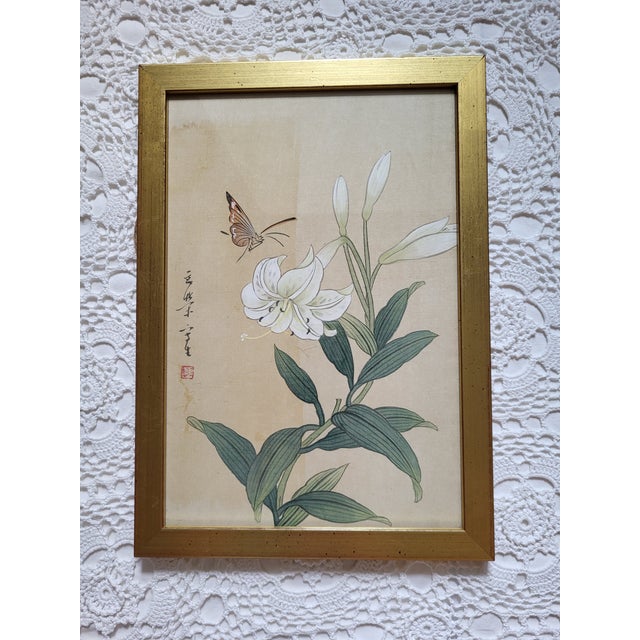 An Asian style butterfly & lily framed art print measuring 13 1/4" x 9 1/2" x 1/2". Perfect for many types of decor.