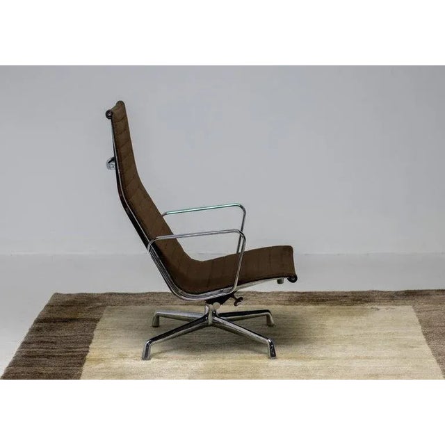 Eames aluminum group lounge chair EA 124 two-tone dark brown Hopsak fabric, manufactured by Herman Miller. The chair is...