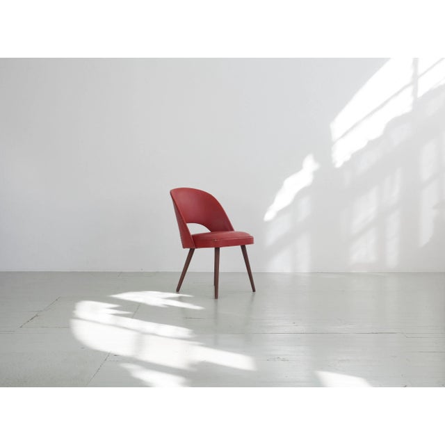 The relatively small cocktail chair covered with a solid vinyl cover, the seams of which are stabilized by a piping strip....