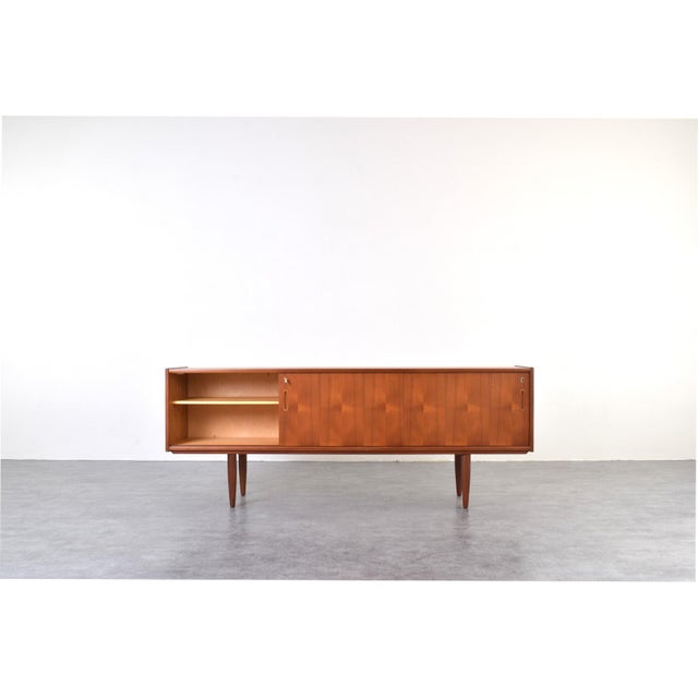 This teak sideboard was manufactured in Denmark in the 1960s. The piece has been professionally and carefully restored by...