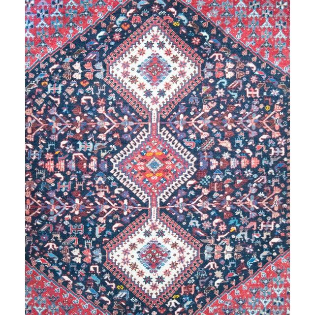 A classic vintage Persian Shiraz rug with three large diamond medallions set against a field of densely woven stylized...