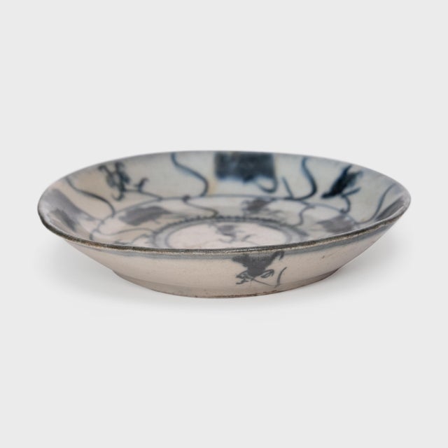 This 19th-century porcelain plate is hand-painted with dark cobalt underglaze in the blue-and-white manner, loosely...