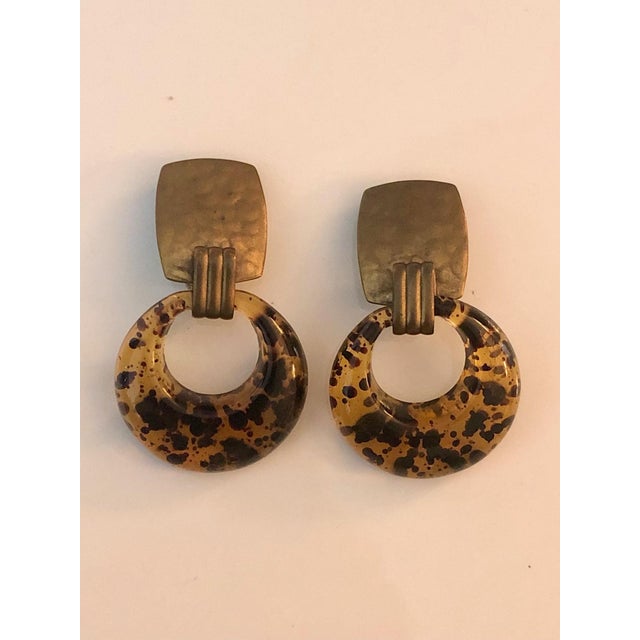 These fabulous 1980s Faux Tortoise Lucite and Gold Door Knocker Earrings will look amazing with any outfit — casual to...