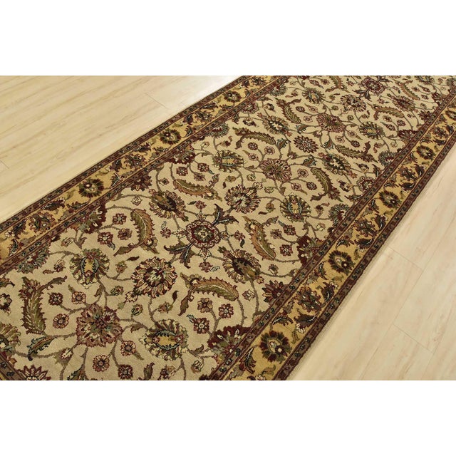 An authentic Agra runner hand-knotted with fine wool on a cotton foundation. This rug features a botanical design set...