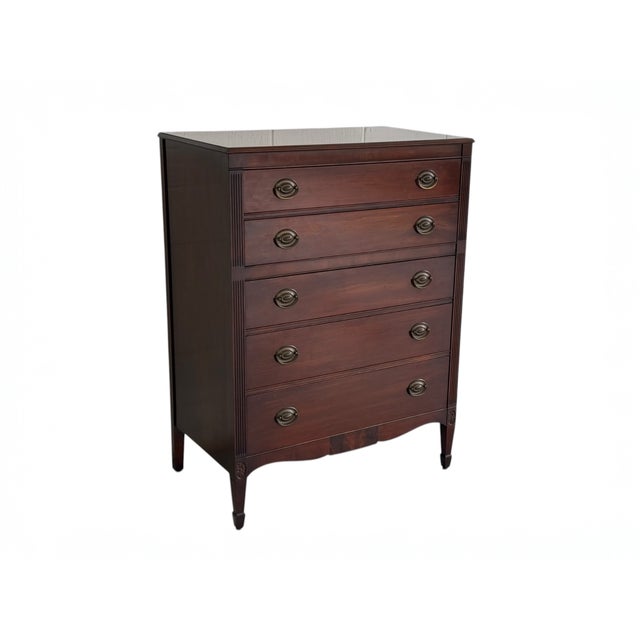 A well-proportioned five-drawer chest by Kindel, featuring fluted corner details and carved rosettes at the feet. The warm...