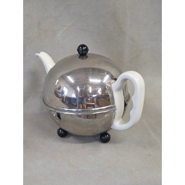 A charming and functional vintage 1930s or 1940s Art Deco creamware porcelain teapot which sits inside of a clever custom...