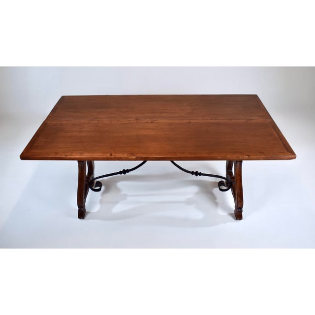 20th century Spanish fold out dining table with banded top, two dovetail drawers and hand forged Iron stretcher. Versatile...