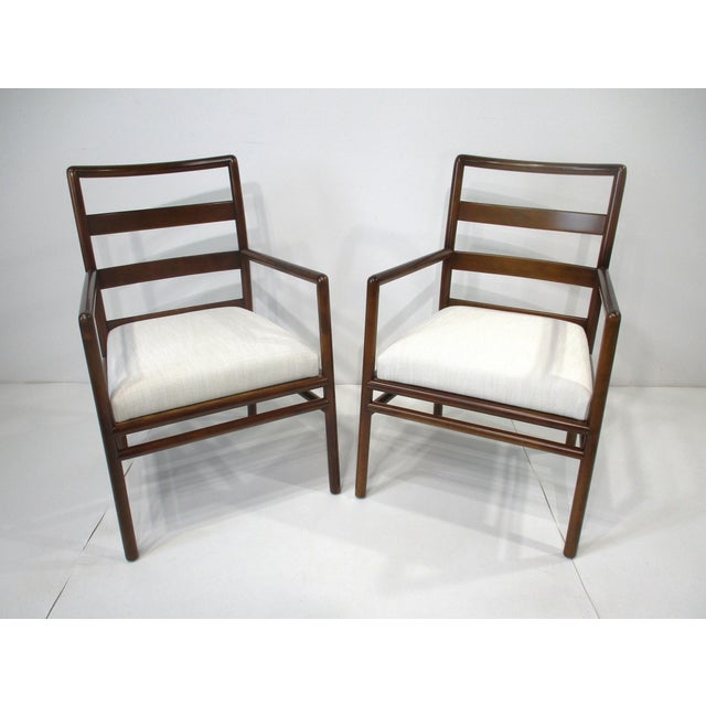 A pair of matching sophisticated dark mahogany ladder backed armchairs with cream upholstered fabric seats. This well-...