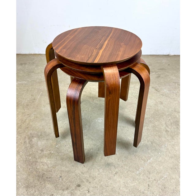 A beautiful set of three European teak veneer bentwood stacking “dot” low stools or side tables in the style of Alvar...