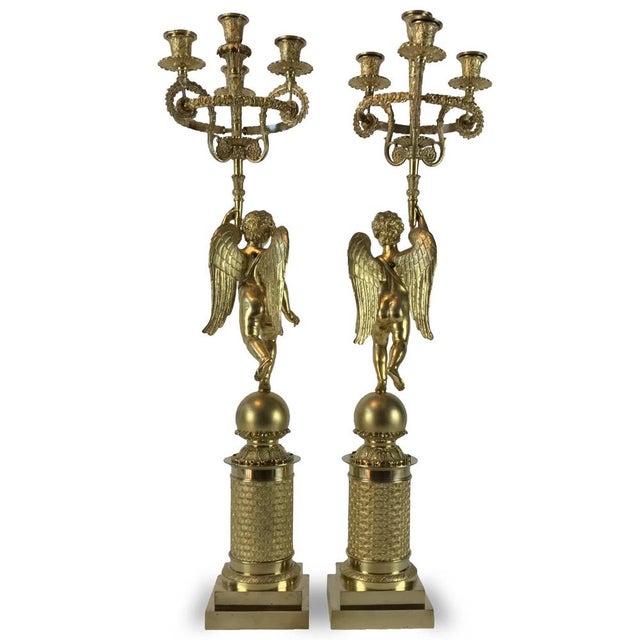 A pair of French Empire gilded bronze candelabra from the early 19th century, ormolu candelabra with cherubs, four flames,...