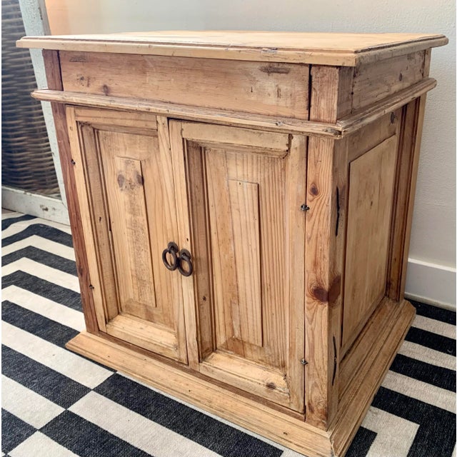 Vintage bare pine rustic end table with 1 drawer and 2 doors, and hand-forged wrought iron pulls. A great piece for living...