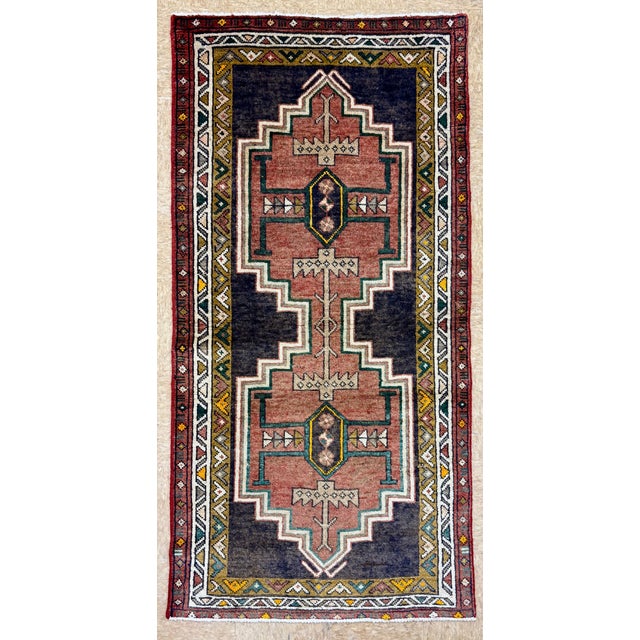 Hand-knotted tribal runner from the Lori tribes of western Iran, featuring two large stepped geometric medallions aligned...